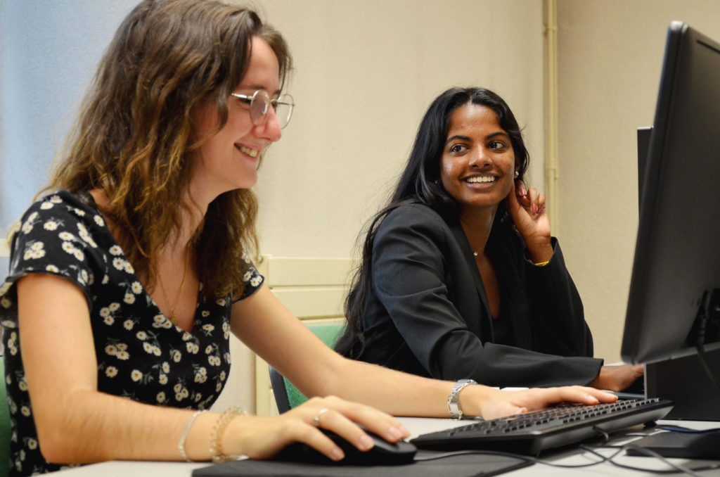 Des étudiantes sourient devant leurs ordinateurs à l'UPVD Mende.